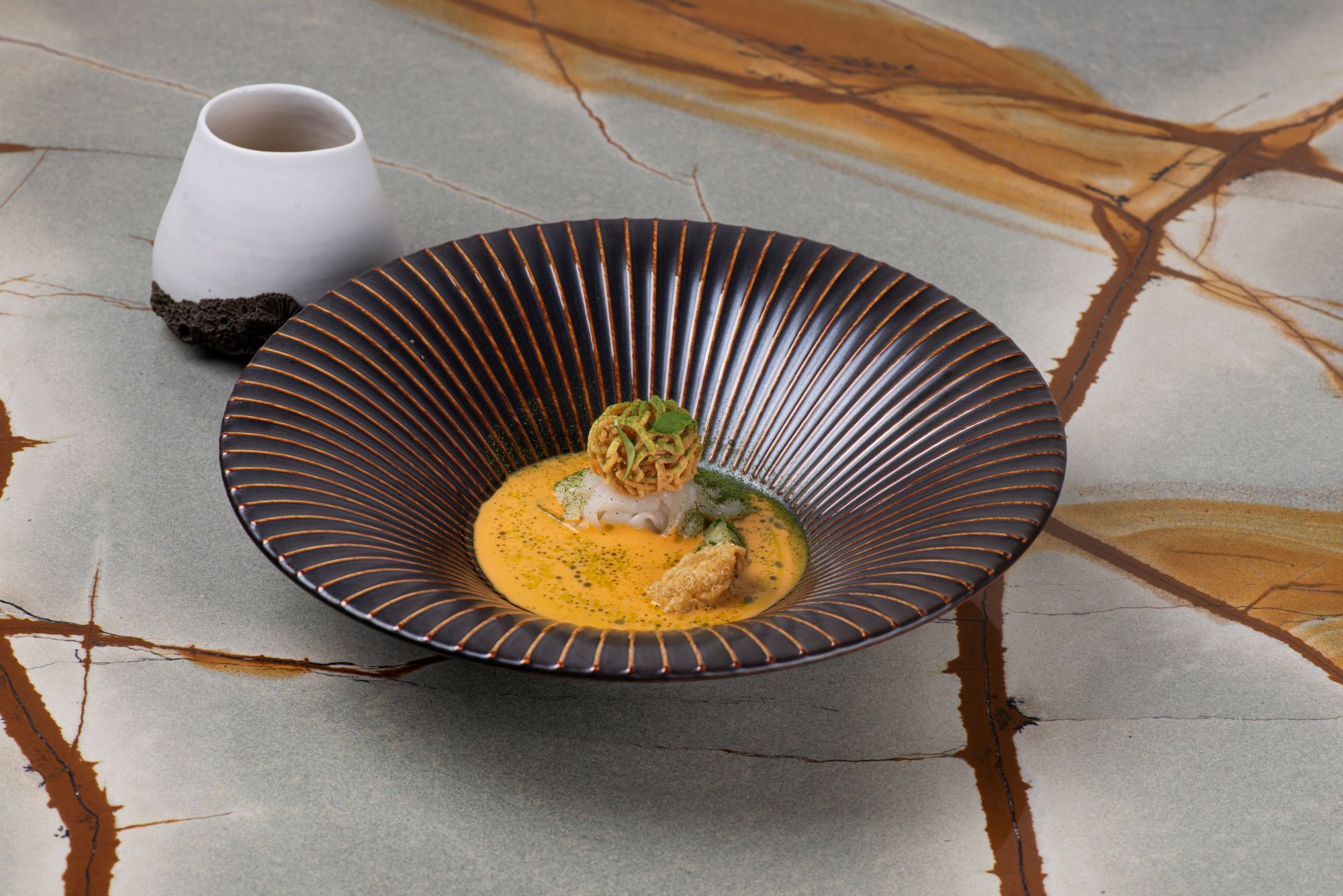 Um tagliatelli de lula curada e sopa khao soi. cuja inspiração vem da Tailãndia